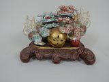 une figurine représentant un masque en or posée sur un socle