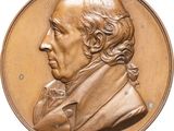 an image of a bronze medallion of a man with long hair and a beard