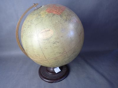 un grand globe terrestre posé sur un socle en bois, muni d'une étiquette
