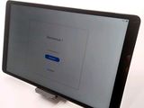 the tablet is sitting on a stand with a screen on it