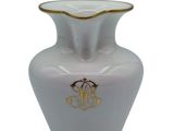 a white vase with a gold decoration on it