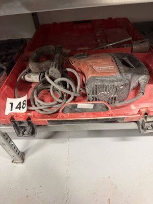 une boîte rouge sur laquelle sont posés une perceuse et d'autres outils