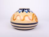 a yellow and blue vase sitting on a white surface