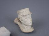 statue of a man with a hat on his head next to a stone block