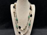 a white mannequin necklace with black and green beads