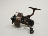 a close up of a fishing reel on a white surface