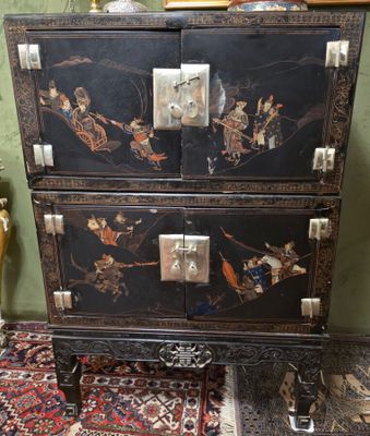 une commode noire ornée de motifs orientaux