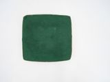 a green square on a white surface with a white background