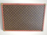 an old louis vuitton suitcase sitting on top of a white surface