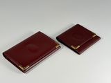 pair of burgundy leather business card cases with gold accents