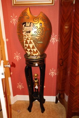 un vase posé sur un socle dans un coin de la pièce