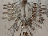 a lot of silver spoons and forks arranged in the shape of a bird