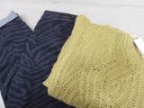 two pairs of pants and a sweater sitting on a table
