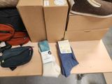 a pile of shoes, a bag, and a pair of socks on a table