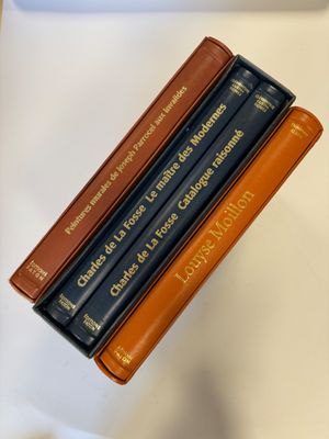 trois livres sont empilés sur une table
