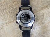 a black watch with a silver face on a wooden table