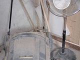 a fan sitting next to a chair in a room
