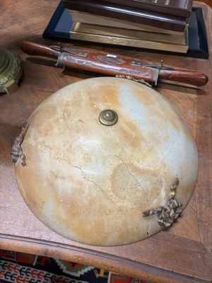 un lavabo en marbre posé sur une table en bois, à côté d'une horloge