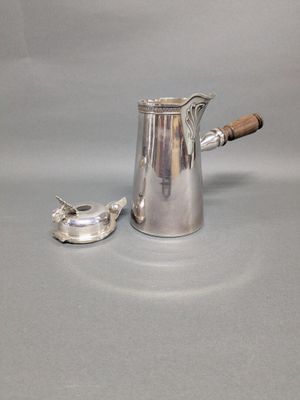 un pichet en argent muni d'une poignée en bois, à côté d'une coupe en argent