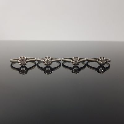 three silver rings on a black surface with reflection