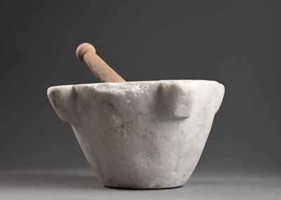 mortier en marbre avec un manche en bois sur fond gris