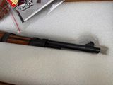 a gun that is sitting on a table next to a bottle of beer