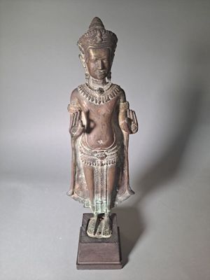 statue d'un homme coiffé d'un chapeau et vêtu d'une robe, posée sur un socle en bois