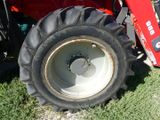 a red tractor that is parked in the grass