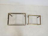 two square brass frames on a white surface