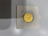une pièce d'or posée sur un morceau de papier