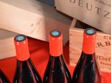 several bottles of red wine sitting on a table next to a wooden crate