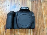 un appareil photo Canon posé sur une table en bois