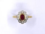 a close up of a gold ring with a red stone