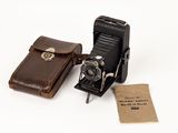 two old cameras sitting next to each other on a white surface