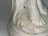 a statue of a woman with her feet on a pedestal