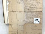 deux feuilles de papier ancien, couvertes d'écriture manuscrite, posées sur une table