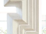 a white sculpture on a table in front of a window