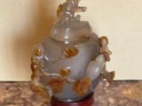 a small glass vase with a figurine on top of it
