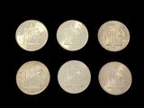 six different types of silver coins on a black background