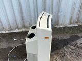 a white toaster sitting on the ground next to a wall