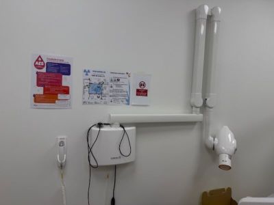 a toilet in a small room with a paper towel dispenser on the wall