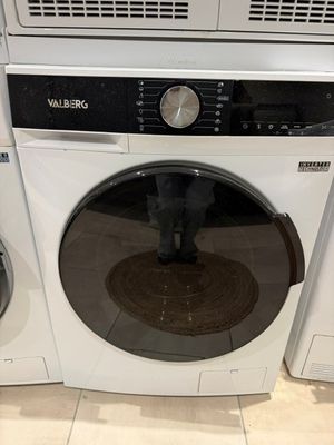 deux lave-linge et un sèche-linge exposés dans un magasin