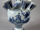 a blue and white vase with three cups in it