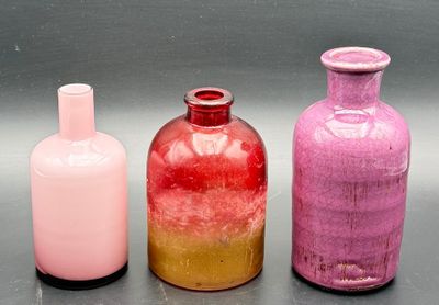 three different colored glass bottles sitting next to each other