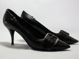 une paire de chaussures noires à talons hauts avec des boucles, sur fond blanc