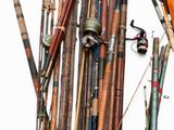 many different types of fishing rods and reels on the table