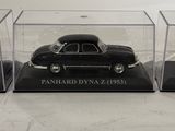 three miniature cars in a display case on a table