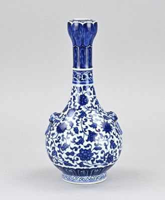 vase bleu et blanc orné de fleurs et de feuilles sur fond blanc