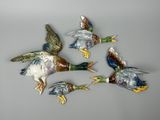 quatre canards volent en cercle sur une surface grise