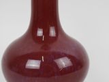 a red vase that is sitting on a table